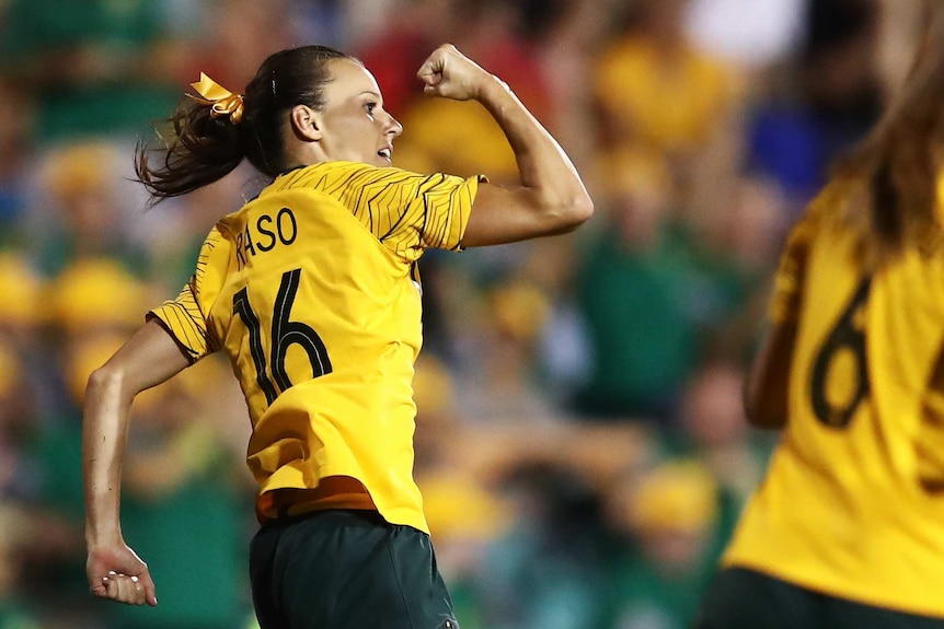 Hayley Raso leaps and punches the air after scoring a goal for Australia.