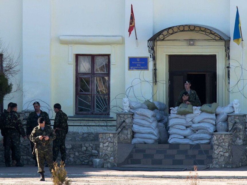 Ukrainian soldiers stand in front of the Crimean naval base in Feodosia