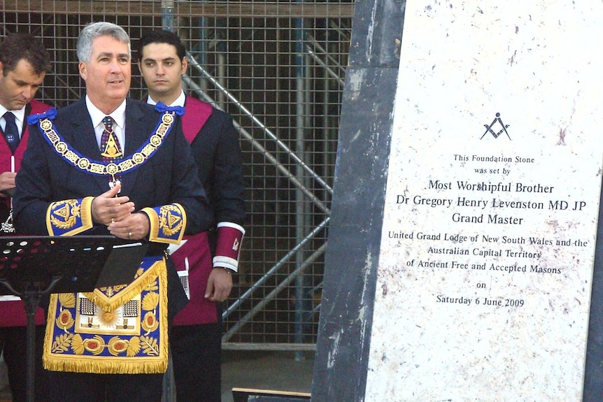 Dr Greg Levenston in full masonic regalia in front of the Canberra Foundation stone.