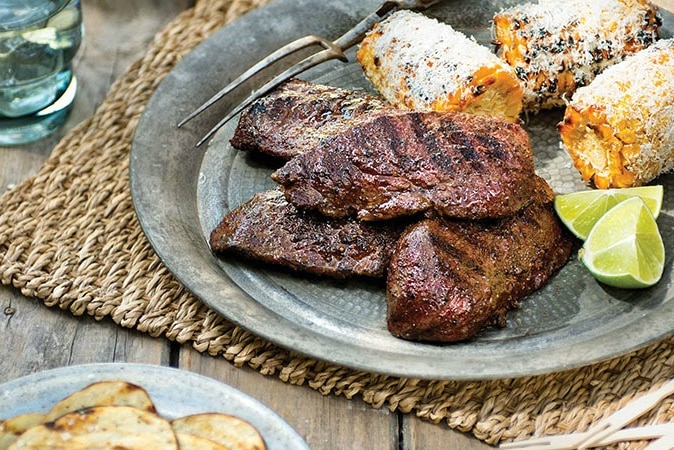 Barbequed kangaroo steaks with chips and sweet corn.