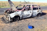 White car burnt out by the roadside