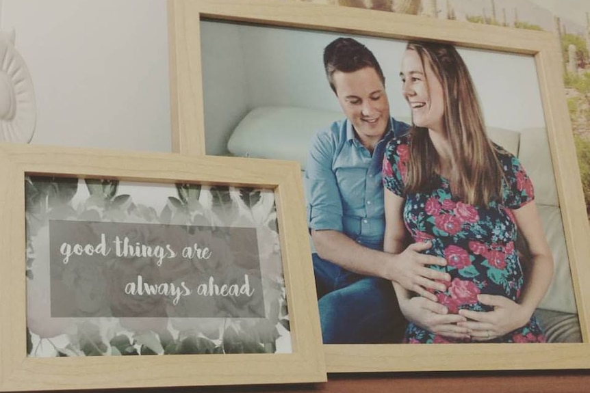 A photo frame with a picture of a pregnant woman and a man smiling and the words 'Good things are always ahead'