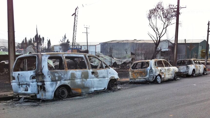 A row of burnt vehicles parked near the oil depot