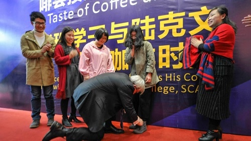 Mr Rudd ties a lady's shoe at a Chinese university (Picture- Wuhan university of Engineering Science website)