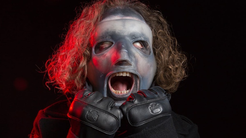 Slipknot's Corey Taylor stretching his new mask on his face
