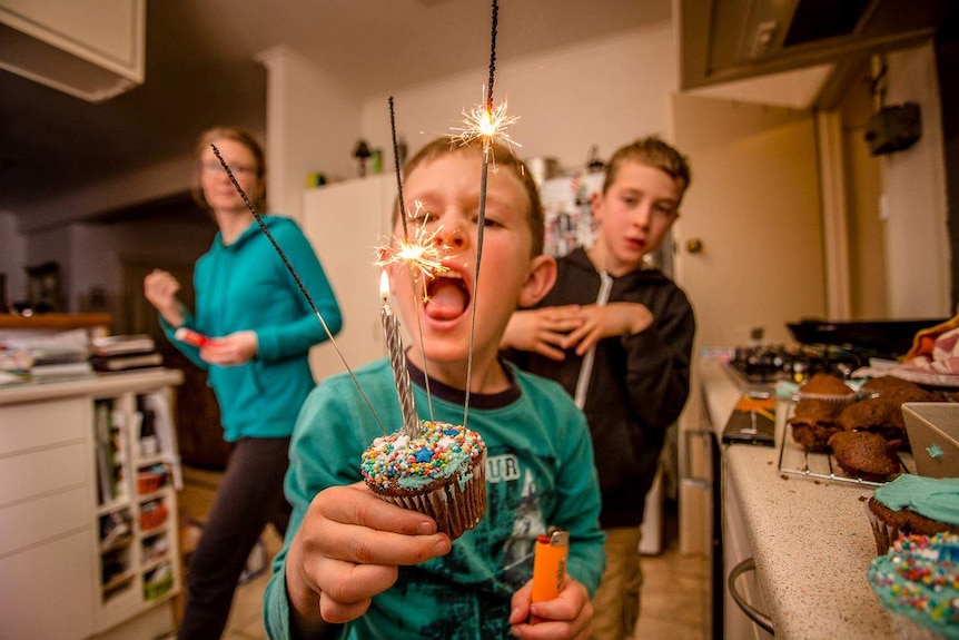 Drew Chislett's son blowing out a sparkler on a cup-cake for his birthday.