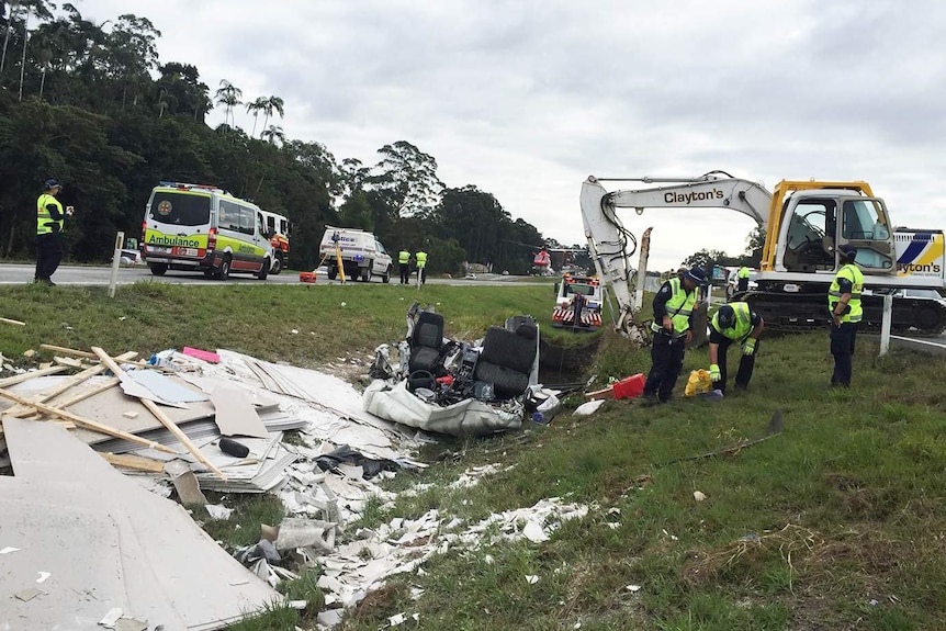 Wreckage from the truck is strewn across the highway median strip