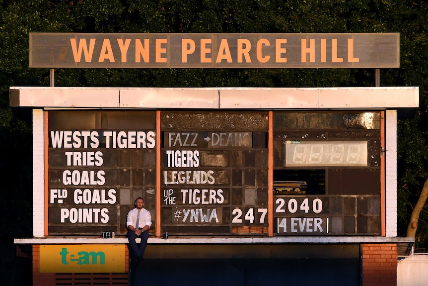 Robbie Farah sits on the Leichhardt Oval scoreboard after the Tigers versus Raiders match in 2016.