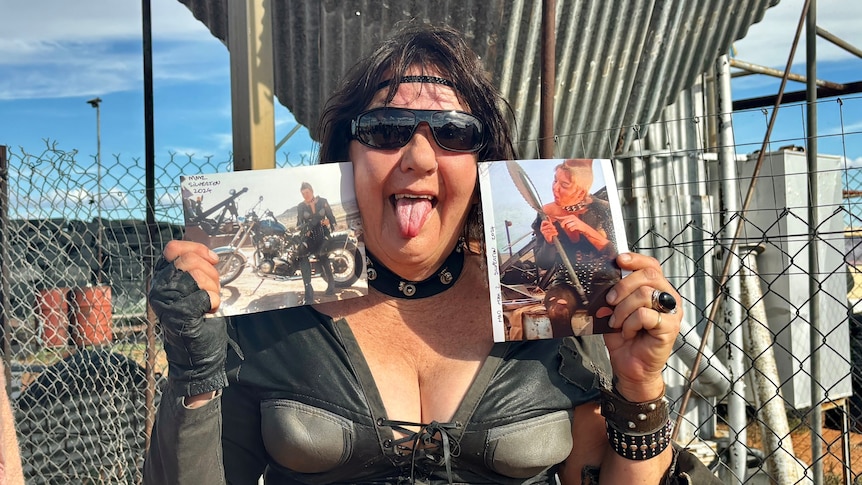A woman holds two pictures beside her face and sticks out her tongue.
