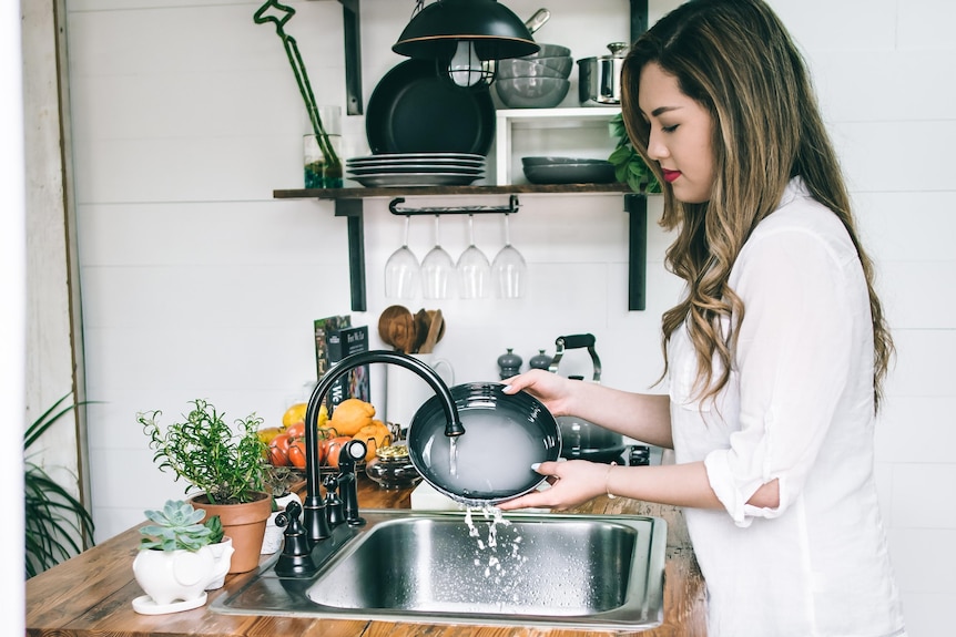 Woman hand-washing a pot