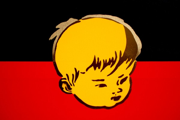 A painting of an Aboriginal flag with the face of a Chinese boy