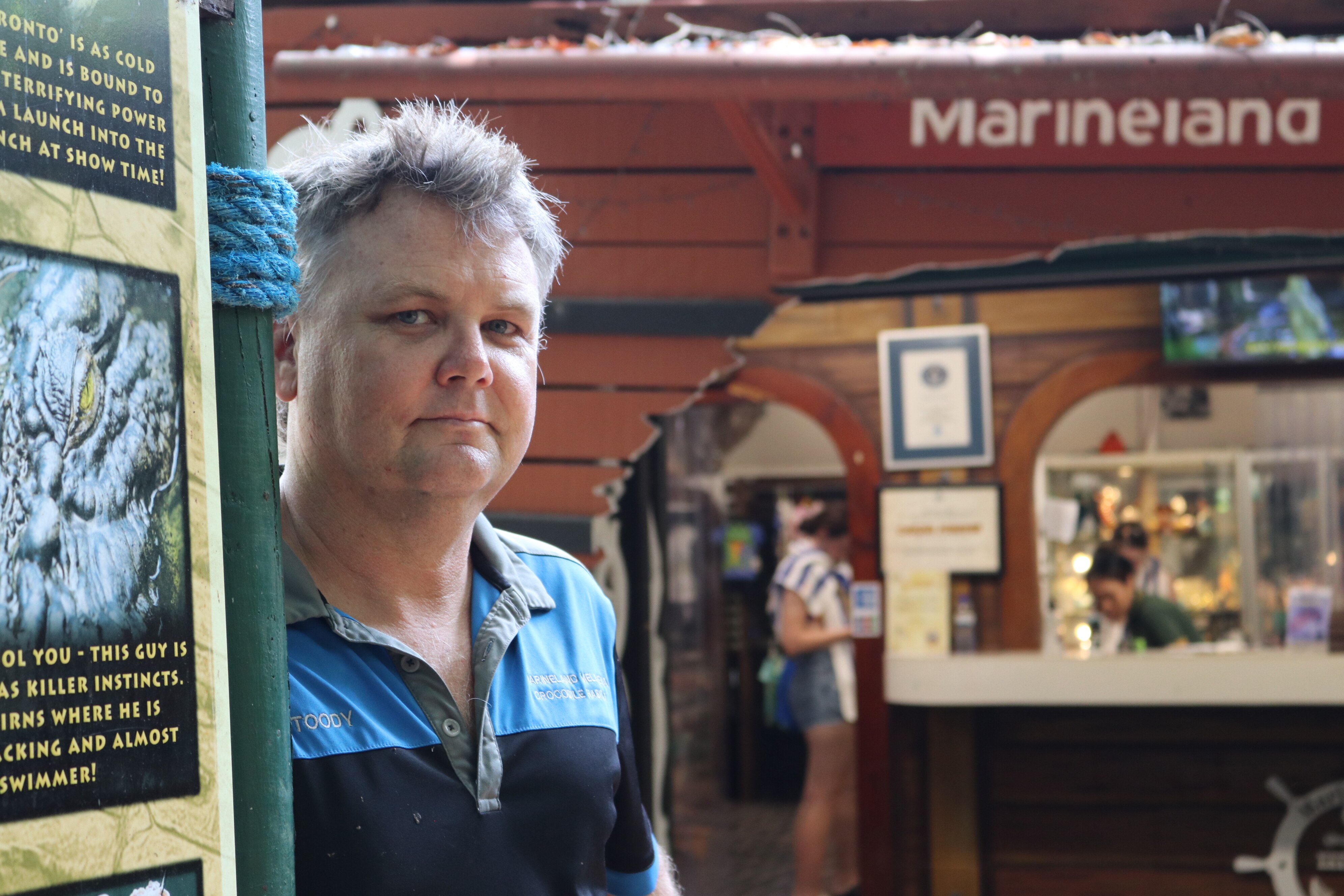 Retrato de un hombre parado junto a un cartel que decía 