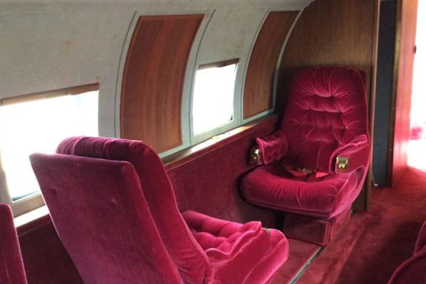 The interior of the 1962 Lockheed Jetstar, with red velvet seats and red carpet.