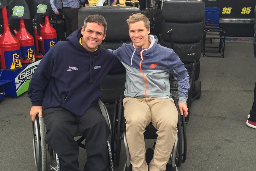 Sam Willoughby and Bootie Barker smile sitting next to each other in wheelchairs with Sam's arm around Bootie