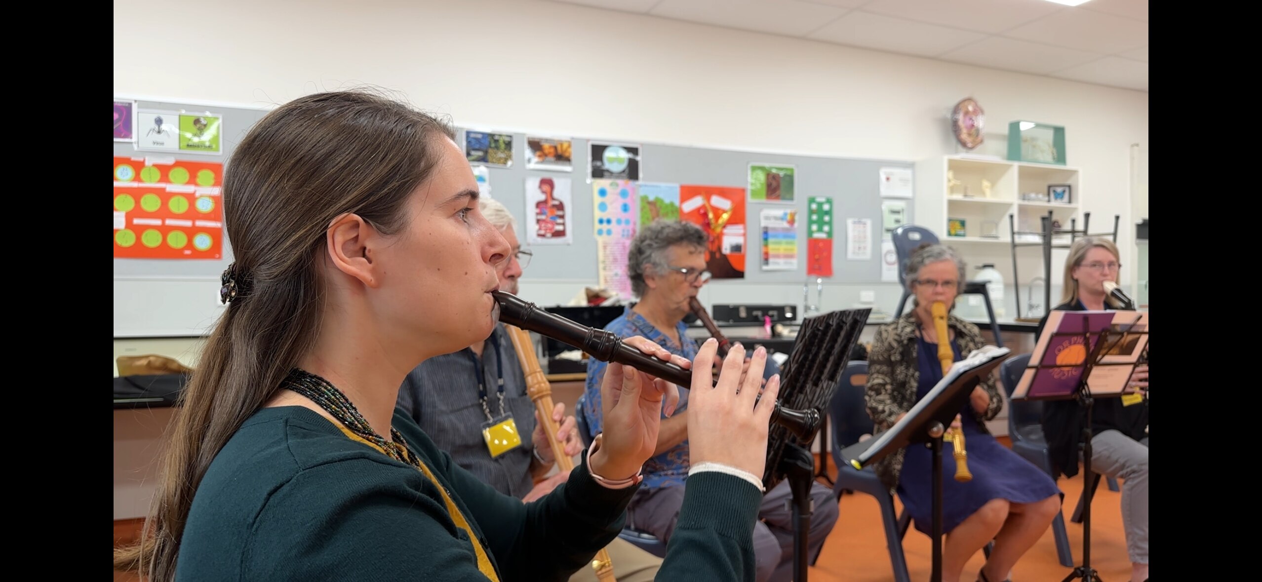 An ensemble of recorder players perform the ABC news theme. 