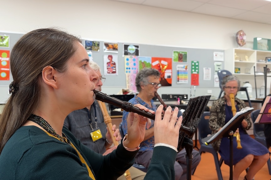 An ensemble of recorder players perform the ABC news theme. 