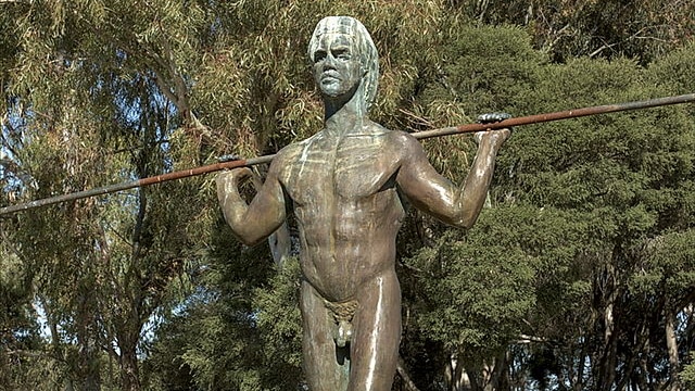 Statue of Indig warrior Yagan in Perth. He's standing and holding a spear on his shoulders