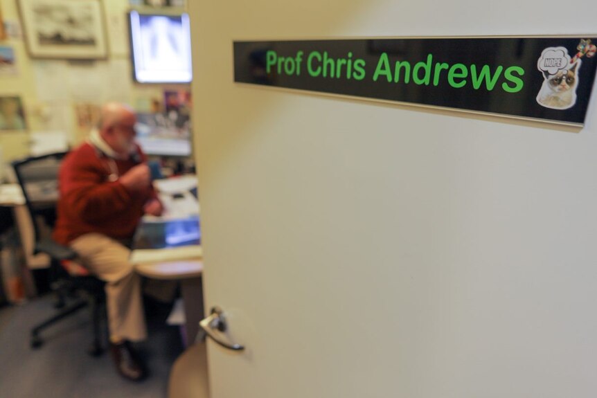 Open door reads "Prof Chris Andrews" with Chris blurred in the background sitting at his desk 