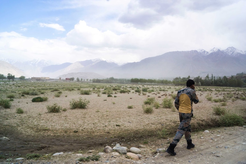 A border guard walking in mountainous terrain