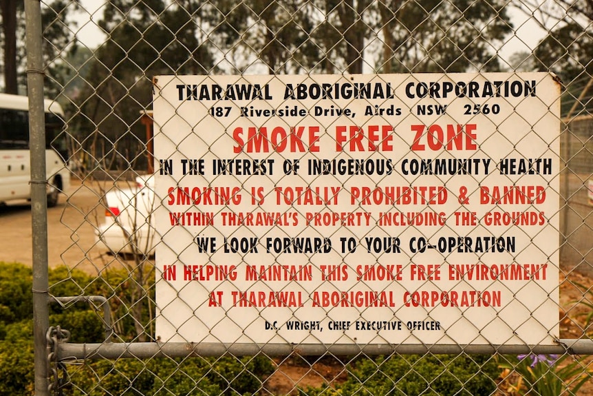 'Smoke free zone' sign on fence outside Tharawal Aboriginal Corporation.