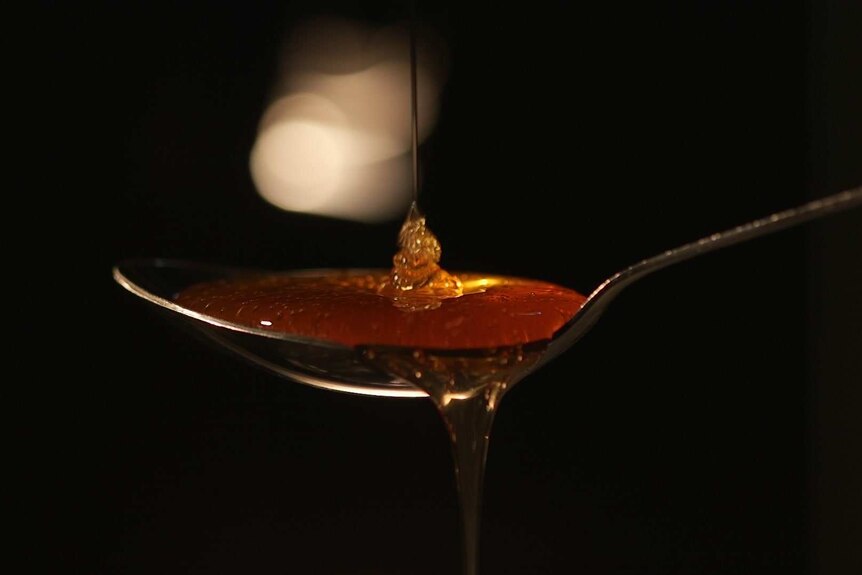 蜂蜜被倒在勺子上。