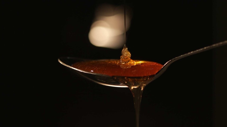 Honey being poured onto a spoon