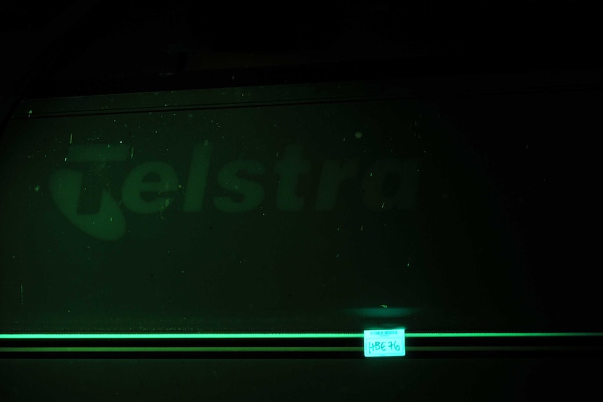 A green lit Telstra logo on the side of the car.