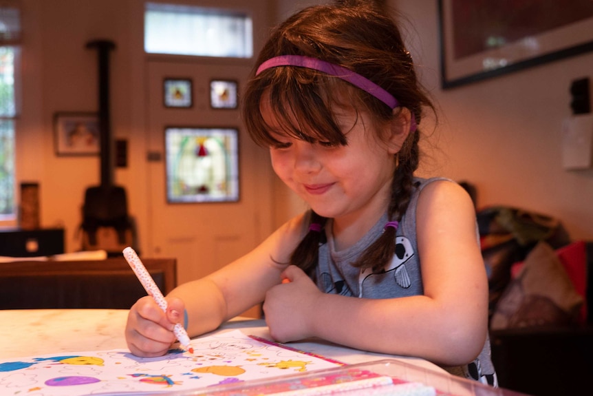 Imogen Munkara-Kerr sits at her dining table.