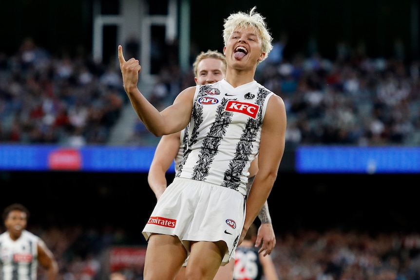 A Collingwood AFL player celebrates a goal against Essendon on Anzac Day.