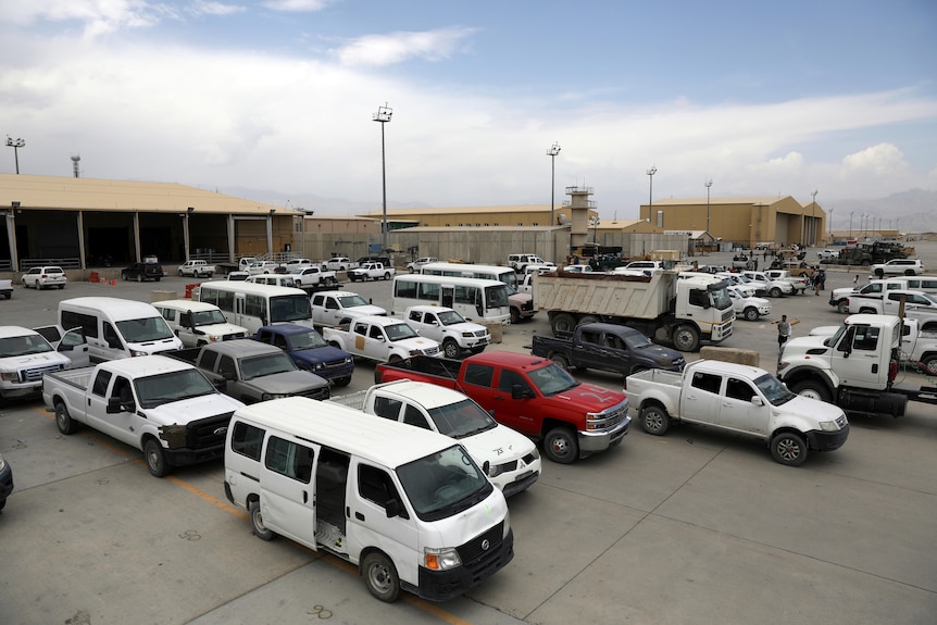 Dozens of cars sit in parking spots at the abandoned Bagram air base
