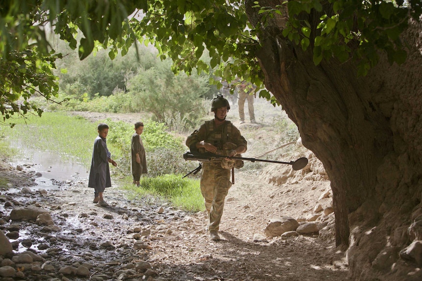 Australian soldier searches for improvised explosive devices