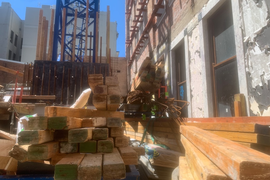 Wooden beams stacked at an inner-city construction site.