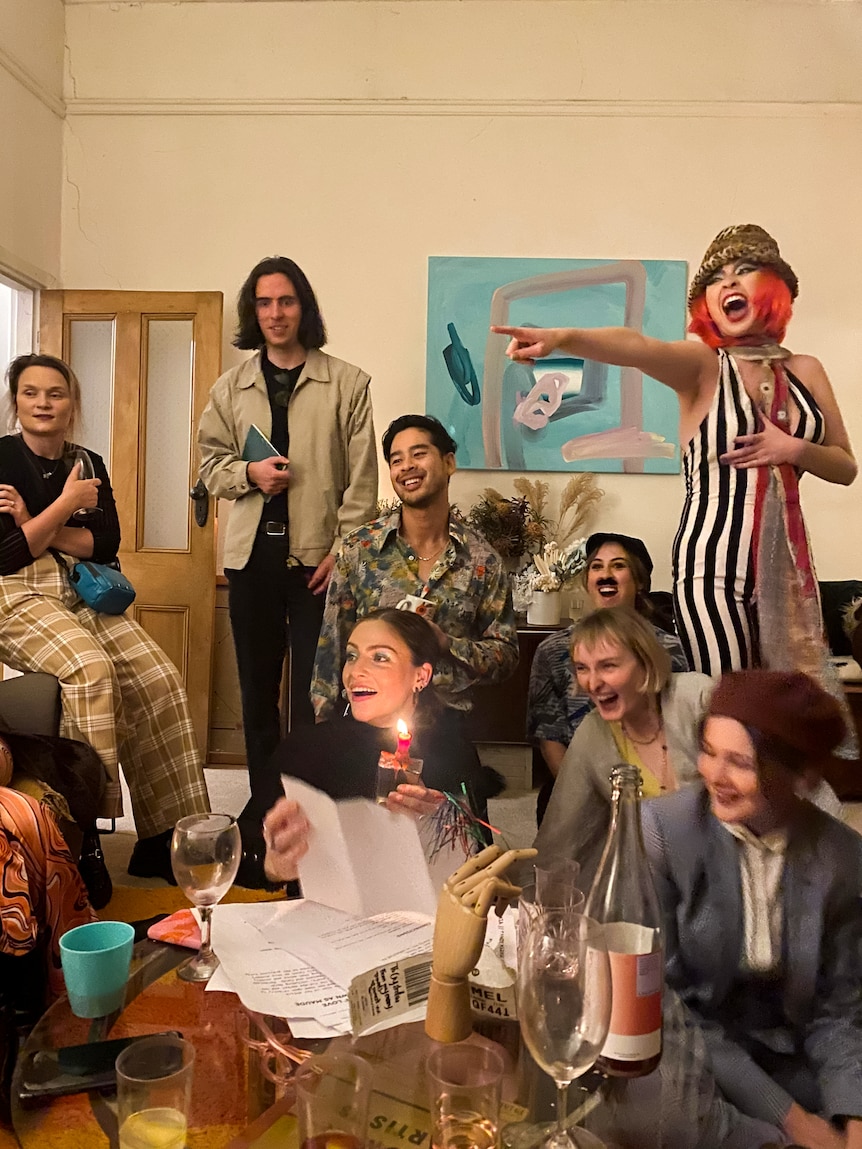 A group of friends in costume in a loungeroom.