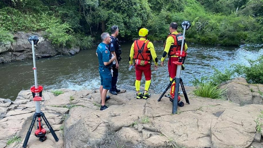 police, ambulance and swift water rescue crews examine a waterfall where a man drowned