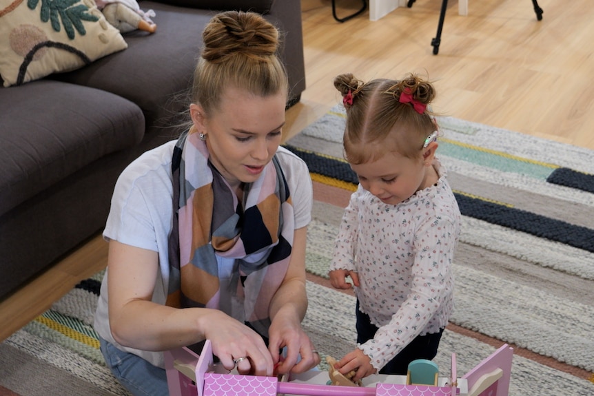 Mum Miff Ward and her daughter Azaria on a rug.