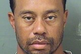 A mugshot of dishevelled tiger woods, with long facial hair.