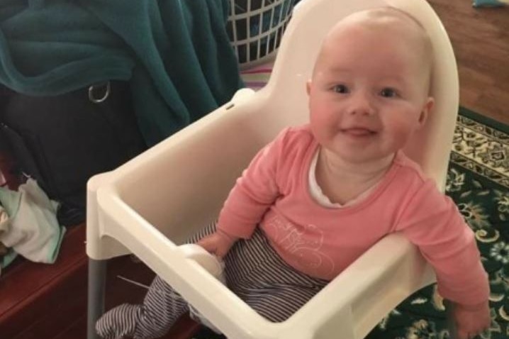 Baby Isabella in a highchair.