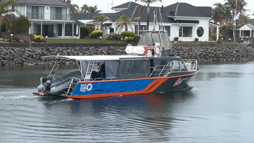 A blue and orange boat in the water.