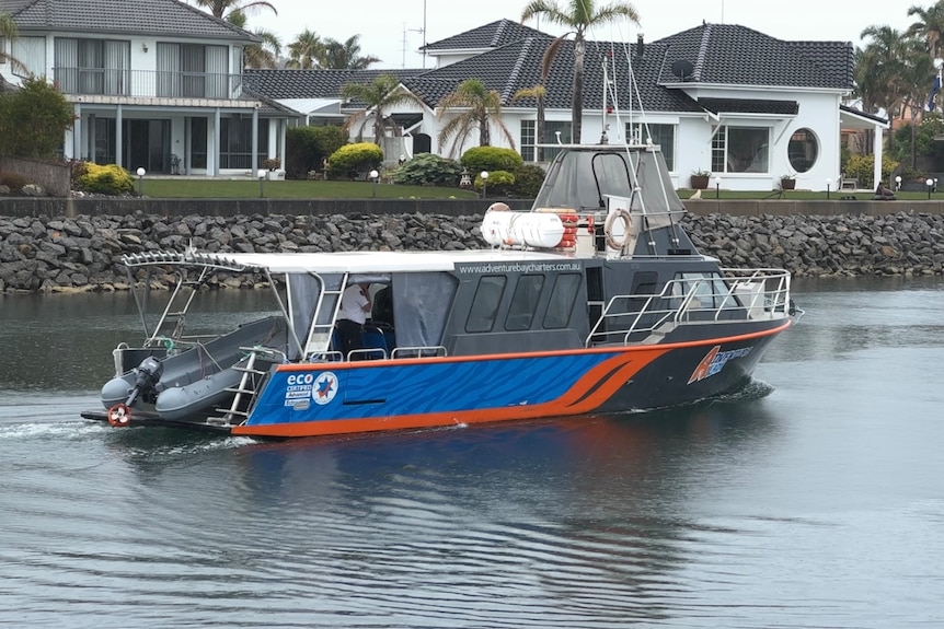 a blue and orange boat in the water.