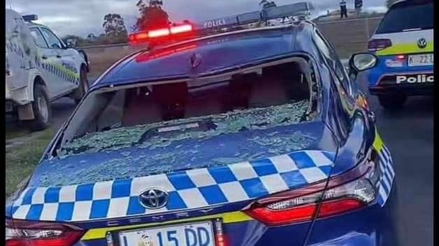 A police car photgraphed from the back, showing the rear windscreen smashed in