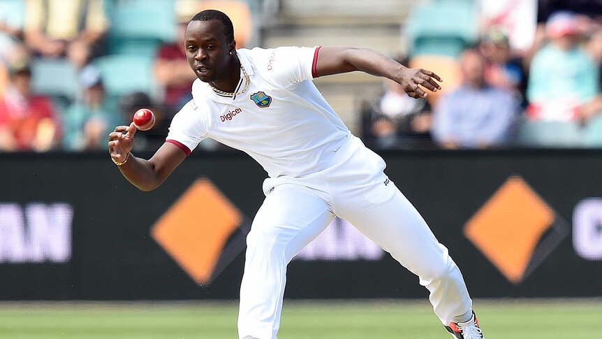 Long day ... West Indies quick Kemar Roach fields the ball from his own bowling against Australia