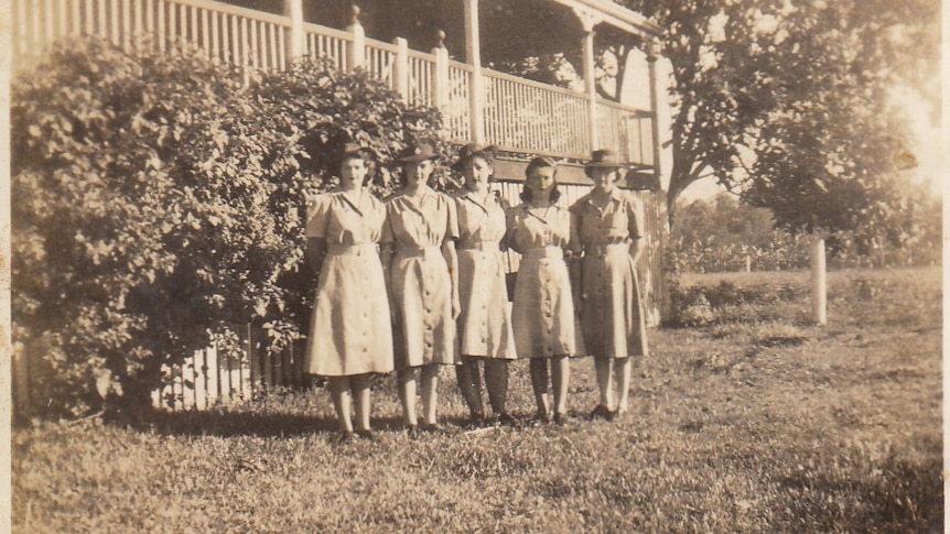 B&W photo of four girls standing in a row.