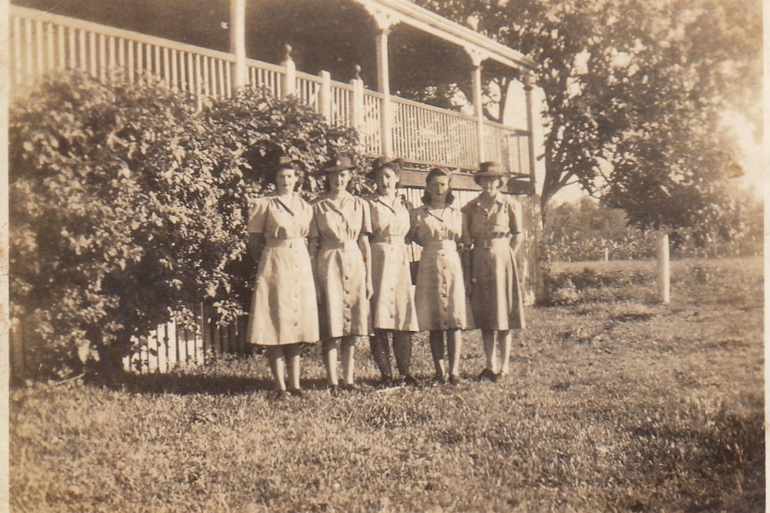 B&W photo of four girls standing in a row.