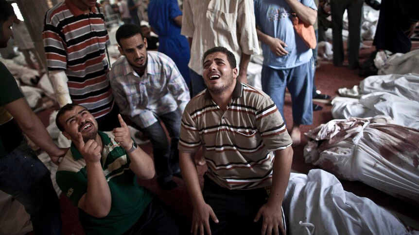 Egyptians mourn next to of bodies wrapped in shrouds at a mosque in Cairo.