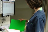 An emergency department nurse inspects medical records