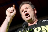 CFMEU secretary John Setka waves his fist in the air as building and construction workers march during a rally in Melbourne.