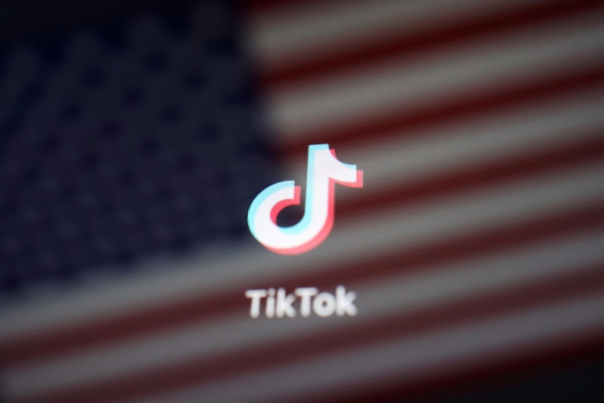 A reflection of the US flag is seen on the sign of the TikTok app in this illustration 