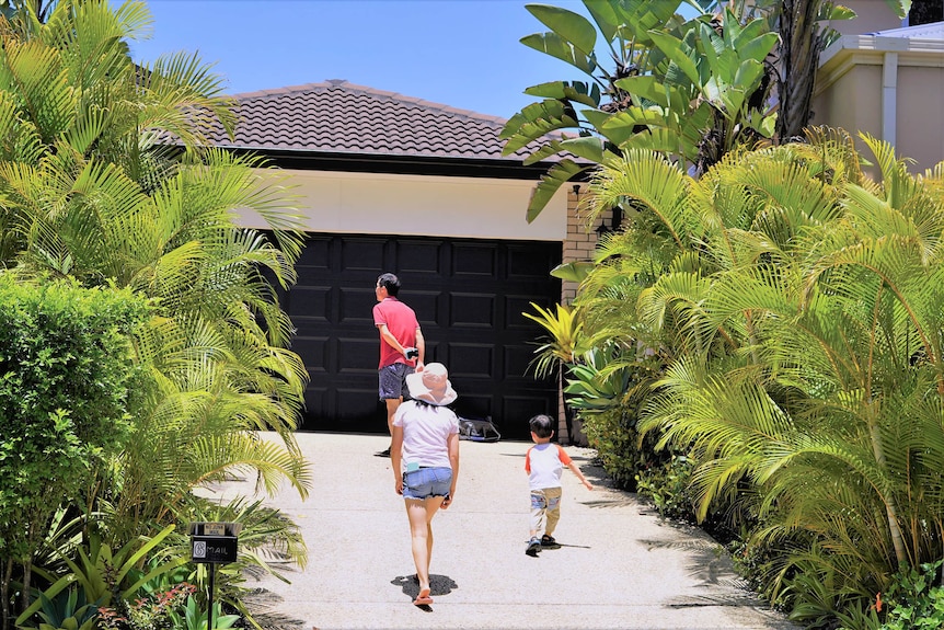 A family walking up the driveway of a house open for inspection