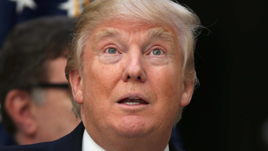 Donald Trump looks upwards with an expressionless look on his face.