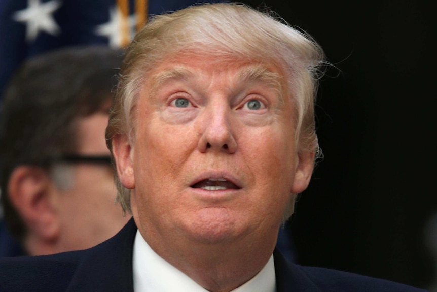 Donald Trump looks upwards with an expressionless look on his face.